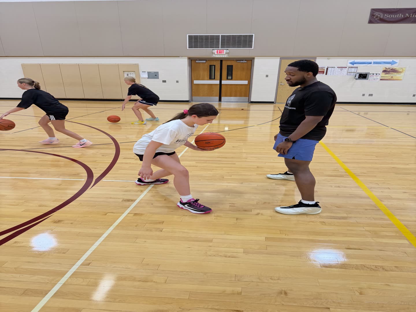 Coach Darrel watching a Grace N Grind athlete work a low ball handling drill