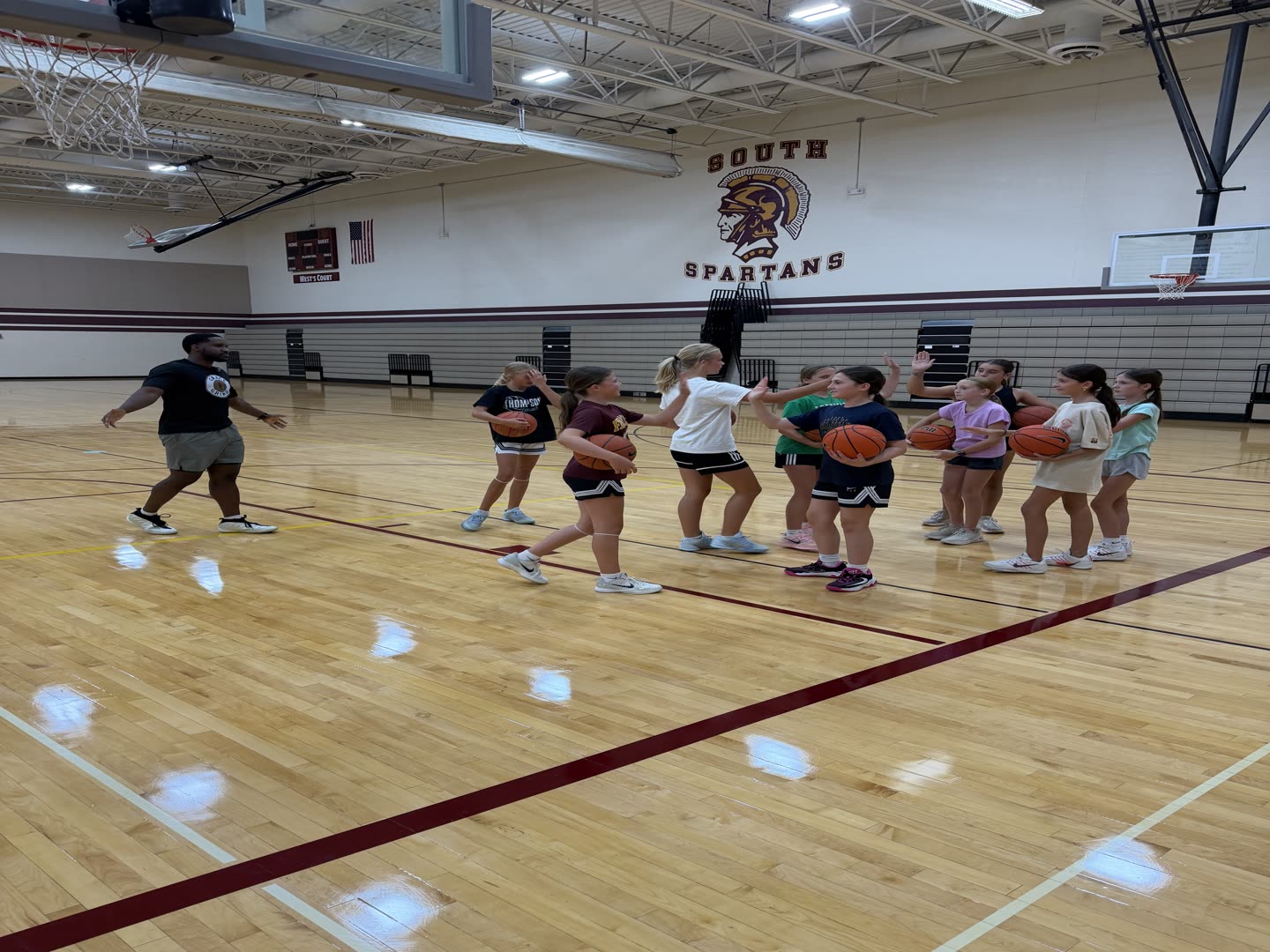 Coach Darrel high-fiving a line of young Grace N Grind athletes